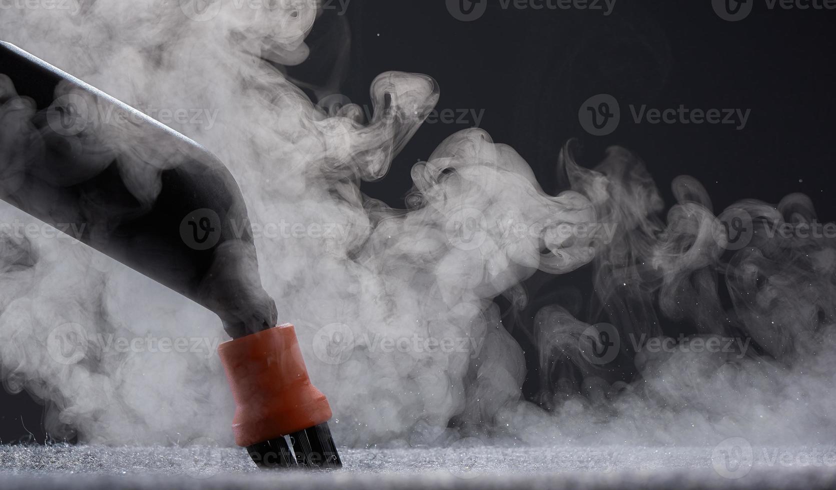 Steam close-up. Steam carpet cleaning on a grey background. Home cleaning. photo