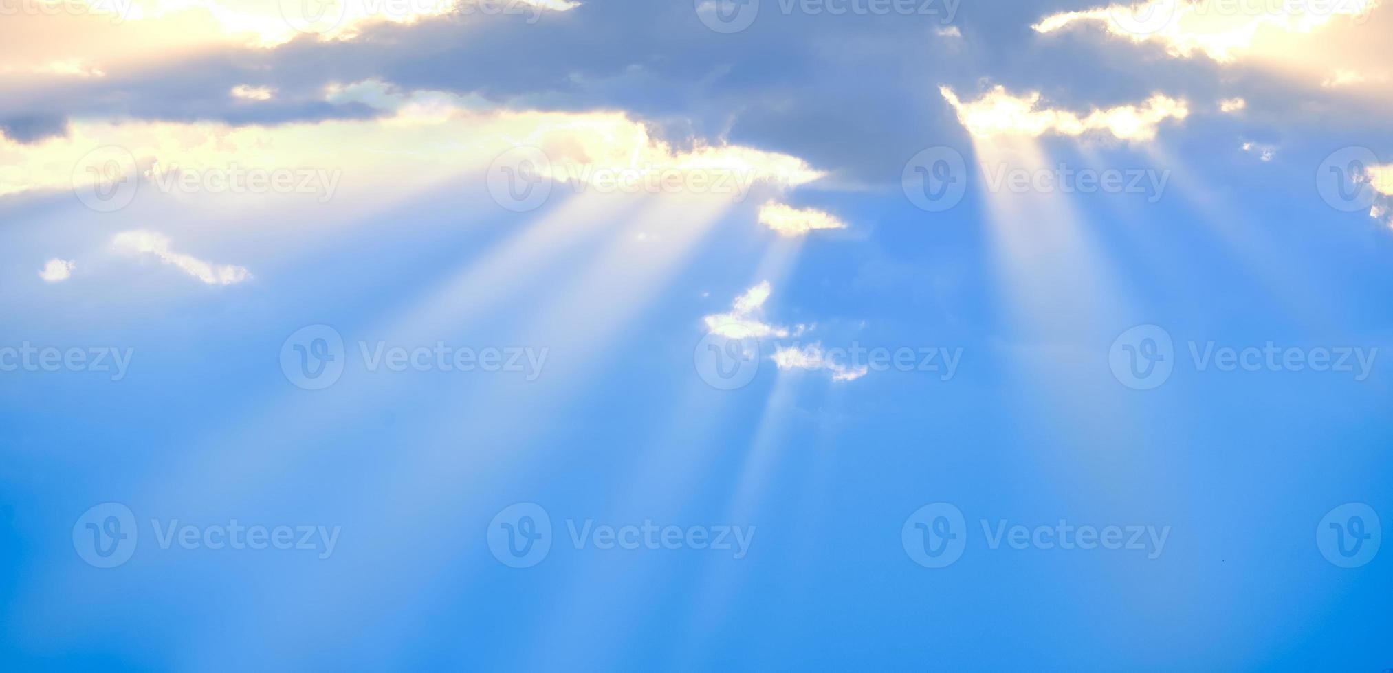The sun's rays break through the blue clouds. The background of the sky. photo