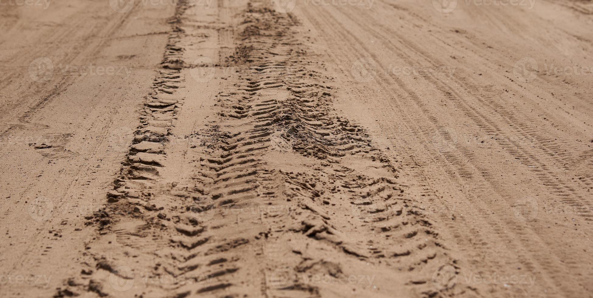 Multiple traces of protectors of heavy trucks on the sand. photo