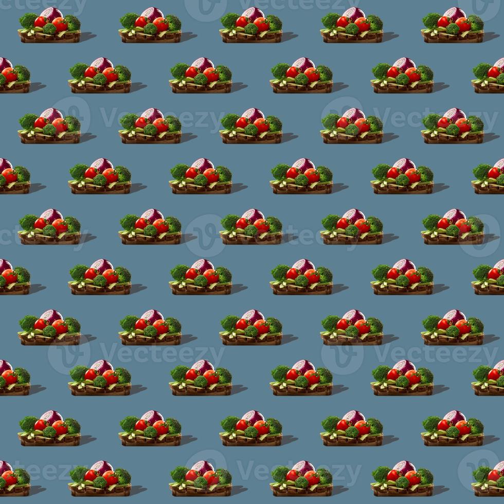 Seamless pattern of healthy vegetables on round wooden board isolated on gray background. photo