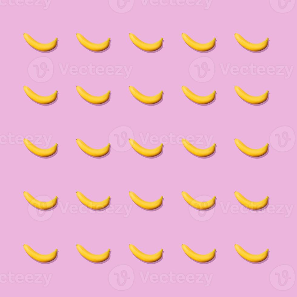 Colorful fruit pattern of fresh yellow bananas on pink background. From top view photo