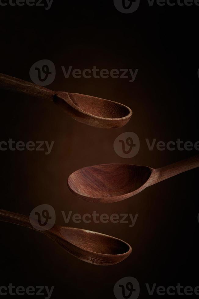 Wooden spoons on a dark brown background. Side view. photo