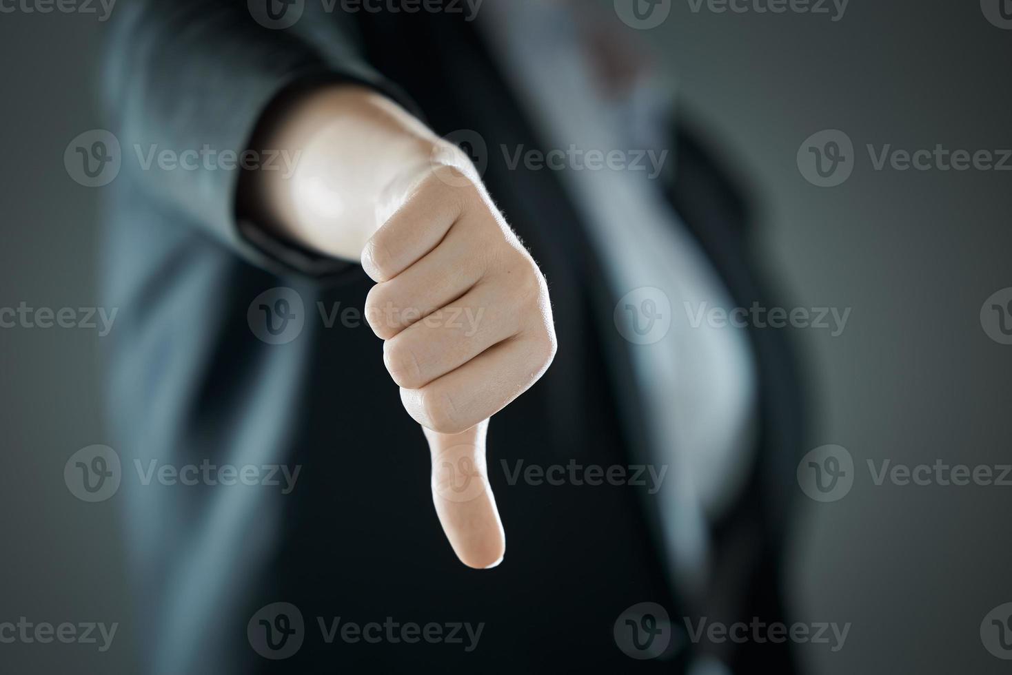 pulgar femenino hacia abajo de cerca en el fondo del traje en desenfoque. concepto de negocio. foto