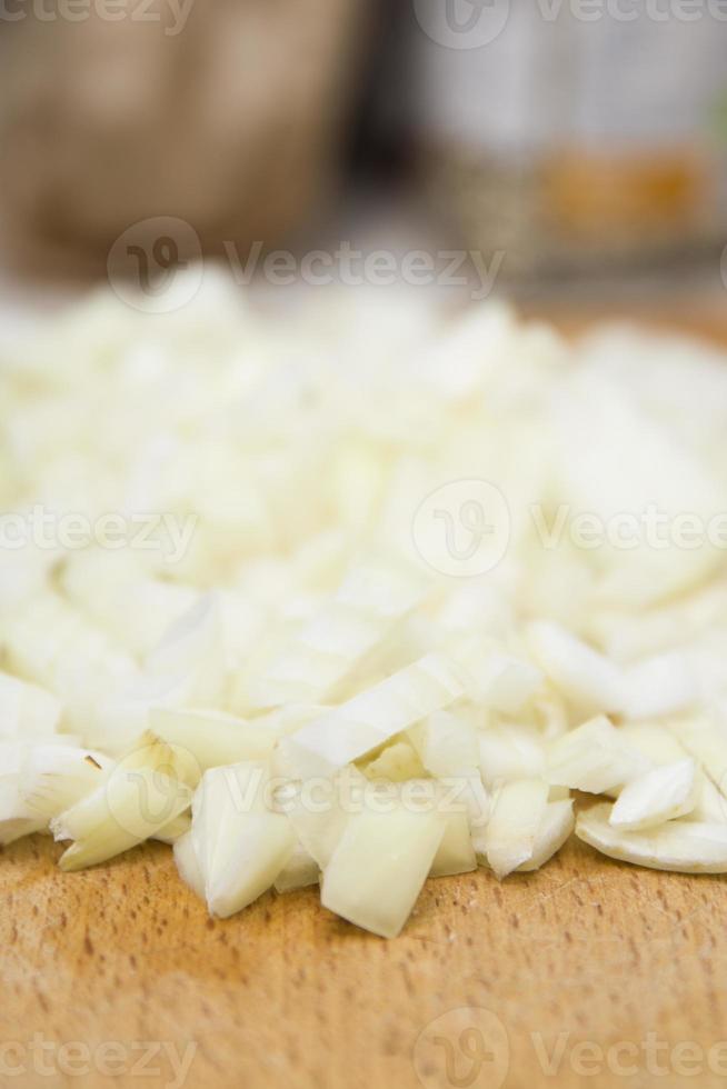 cebollas picadas en tabla de cortar de madera foto