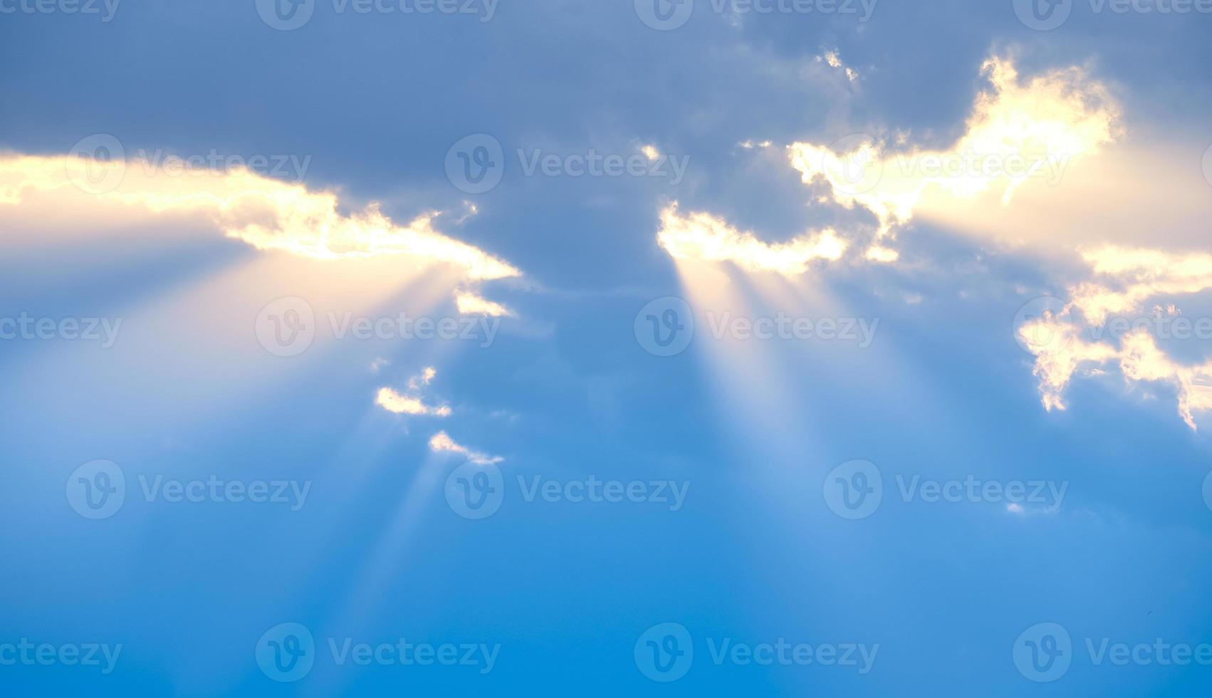 The sun's rays break through the blue clouds. The background of the sky. photo