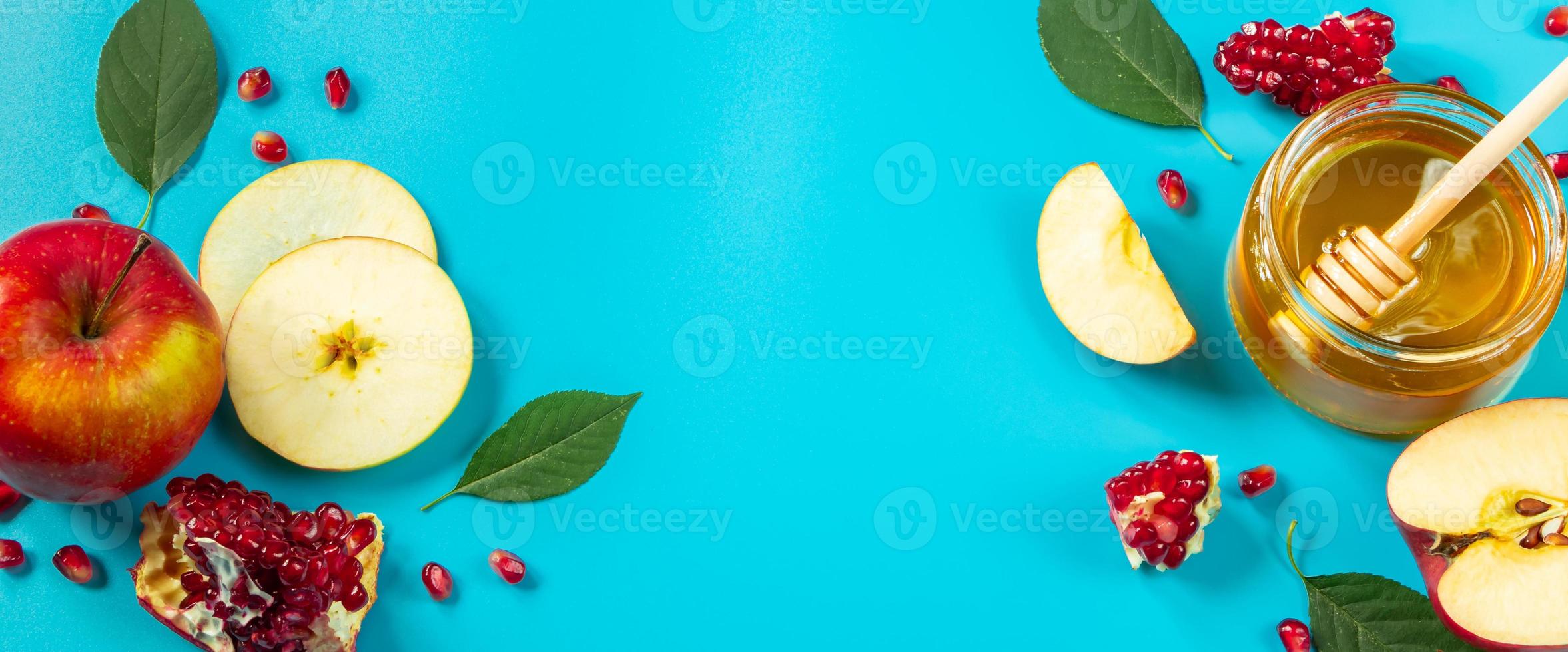 Apples, honey and pomegranates on blue background. Happy Rosh Hashanah. Jewish religious holiday concept. Banner format. photo