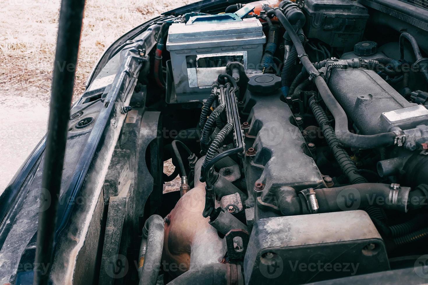Open hood of the car. View of the engine and vehicle parts. Diagnostics and repair of old car. photo