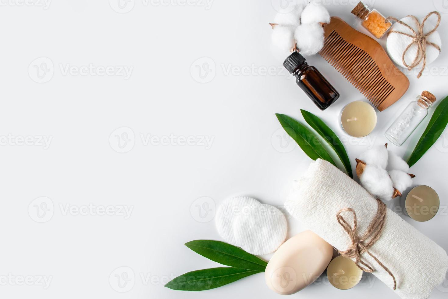 conjunto de cosméticos naturales y accesorios de spa sobre fondo blanco. toalla, jabón, cepillo para el cabello, aceite esencial. foto