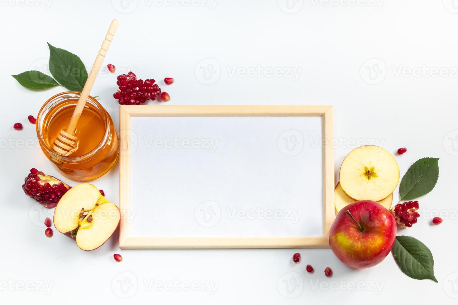 Happy Rosh Hashanah. Frame for congratulatory text. Apples, pomegranates and honey on white background. Traditional Judaism photo