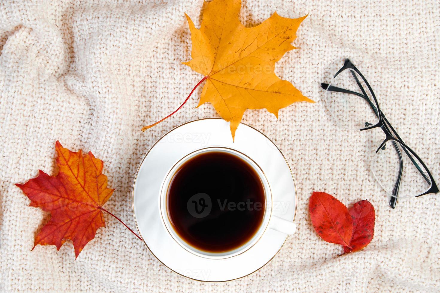 taza de café fuerte caliente y hoja caída. concepto de mañana de otoño. bebida caliente para el frío y jersey de punto. foto