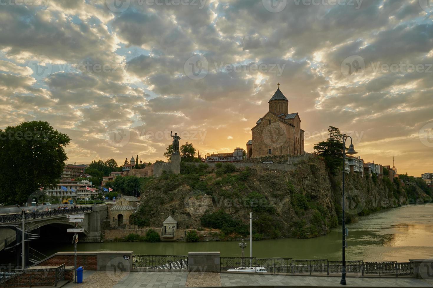 Metekhi Church of the Nativity of the Virgin Mary and the Monument of King Vakhtang Gorgasali in Old Tiblisi , Georgia Sunset view with clouds in the sky in background photo