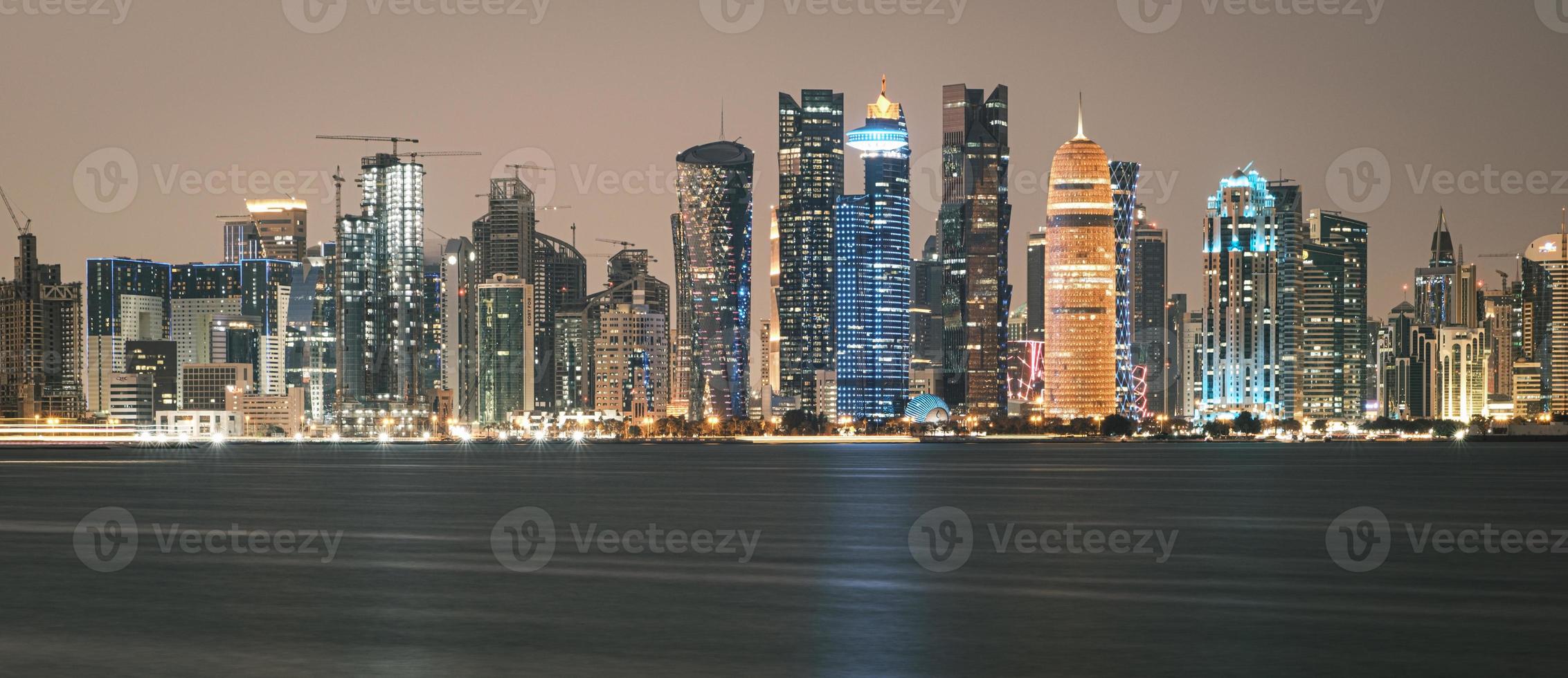 Doha Qatar skyline at night showing skyscrapers lights reflected in the Arabic gulf photo