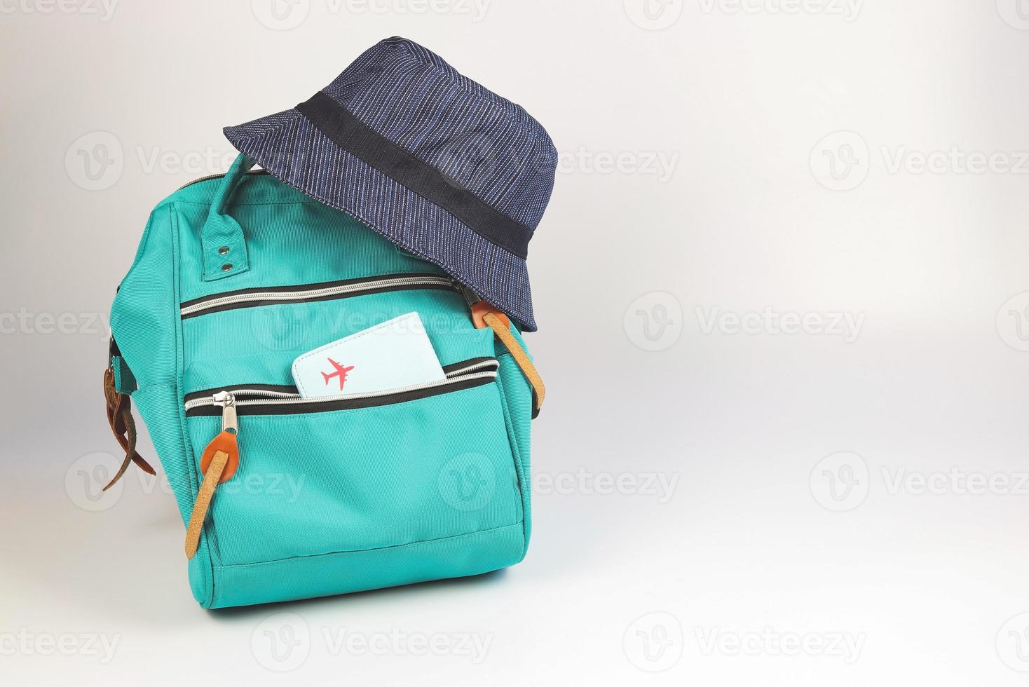 green backpack with passport cover and bucket hat  on white background with copy space.. Travel accessories concept. photo