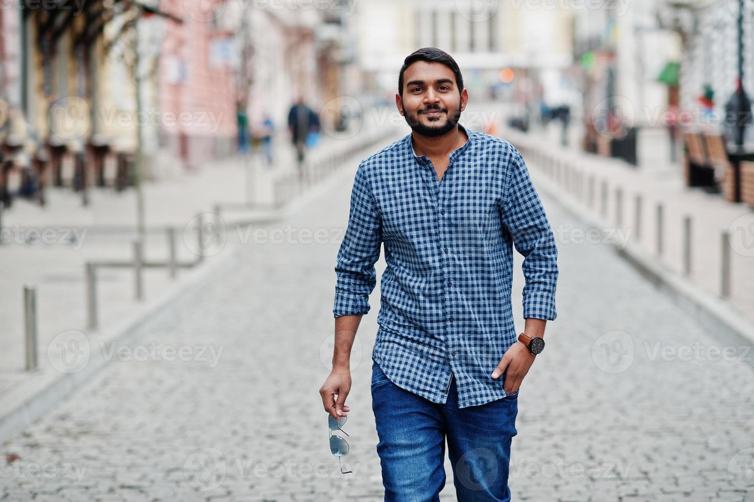 Stylish indian beard model man in casual clothes posed outdoor at street of India. photo