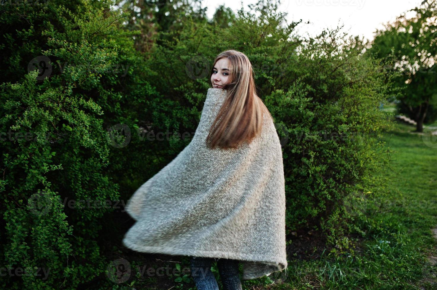Young brunette girl on plaid having fun at evening spring day. photo