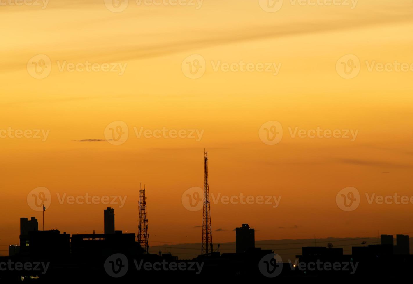 Gives a warm feeling,sunset behind the city building,silhouette city tall buildings,building silhouette again beautiful sky background and freedom concept. photo