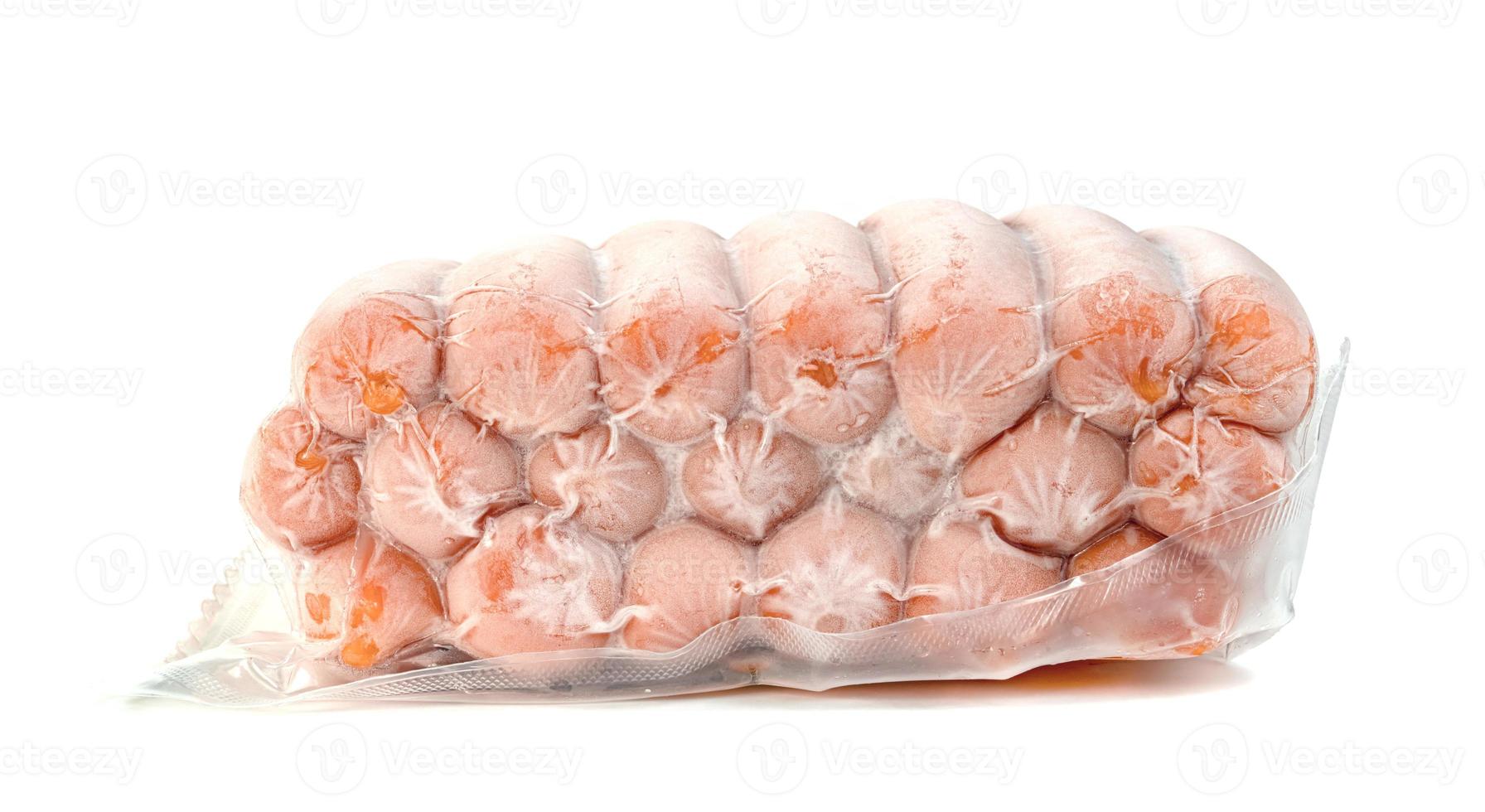 closeup frozen sausage in plastic bag with ice crystals isolated on white background photo