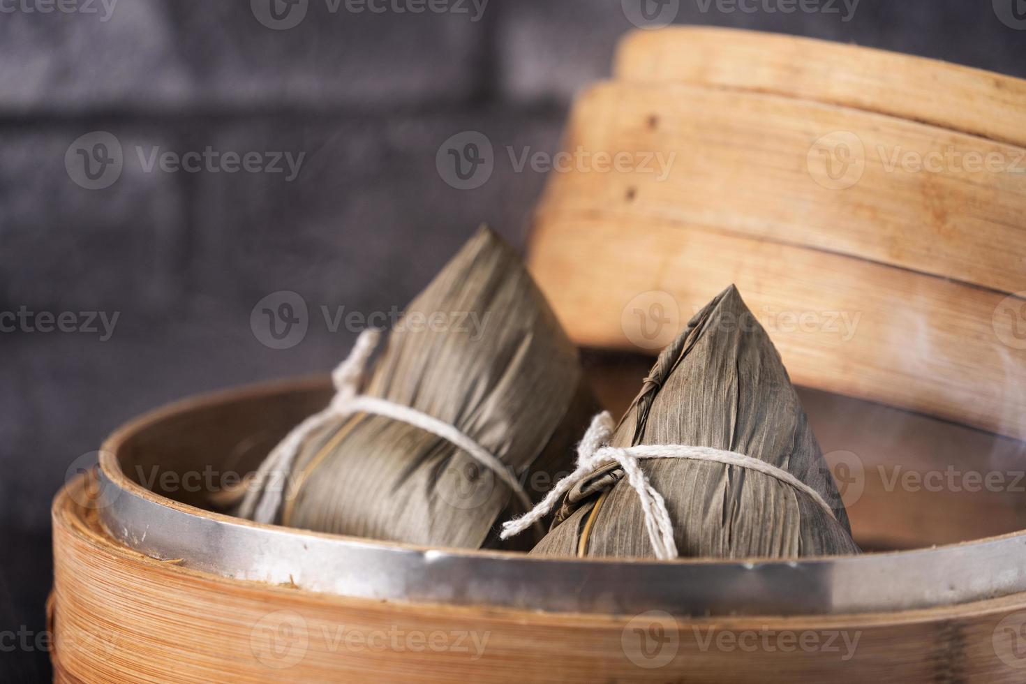 Rice dumpling, zongzi - Chinese rice dumpling zongzi on black brick background slate table, concept of Dragon Boat Festival traditional food, close up. photo