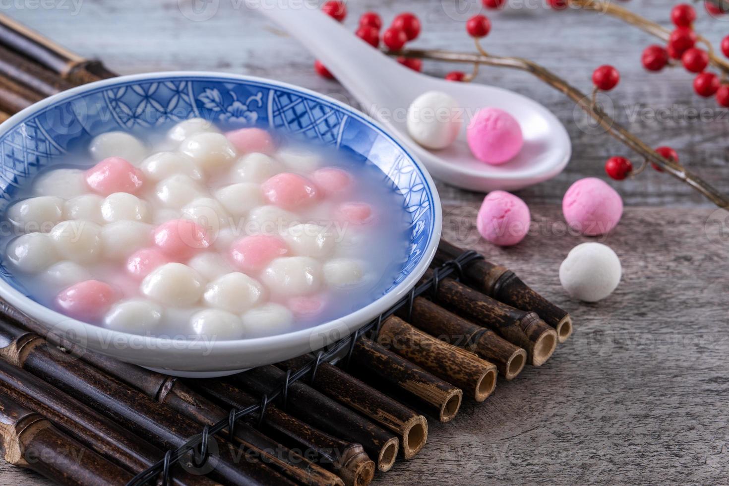 Close up of red and white tangyuan in blue bowl on wooden background for Winter solstice. photo