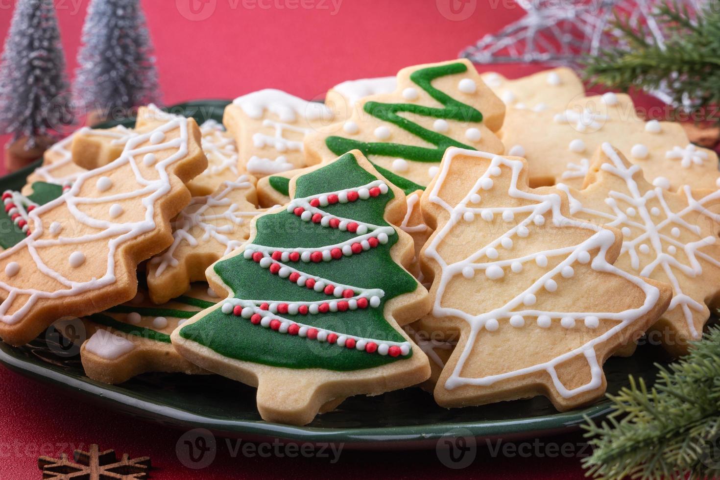 Close up of Christmas sugar cooikes in a plate on red table background. photo