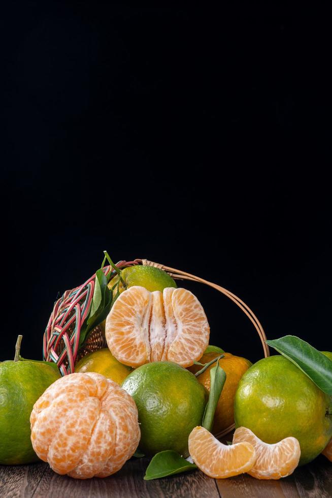 Fresh green tangerine mandarin orange on dark wooden table background. photo