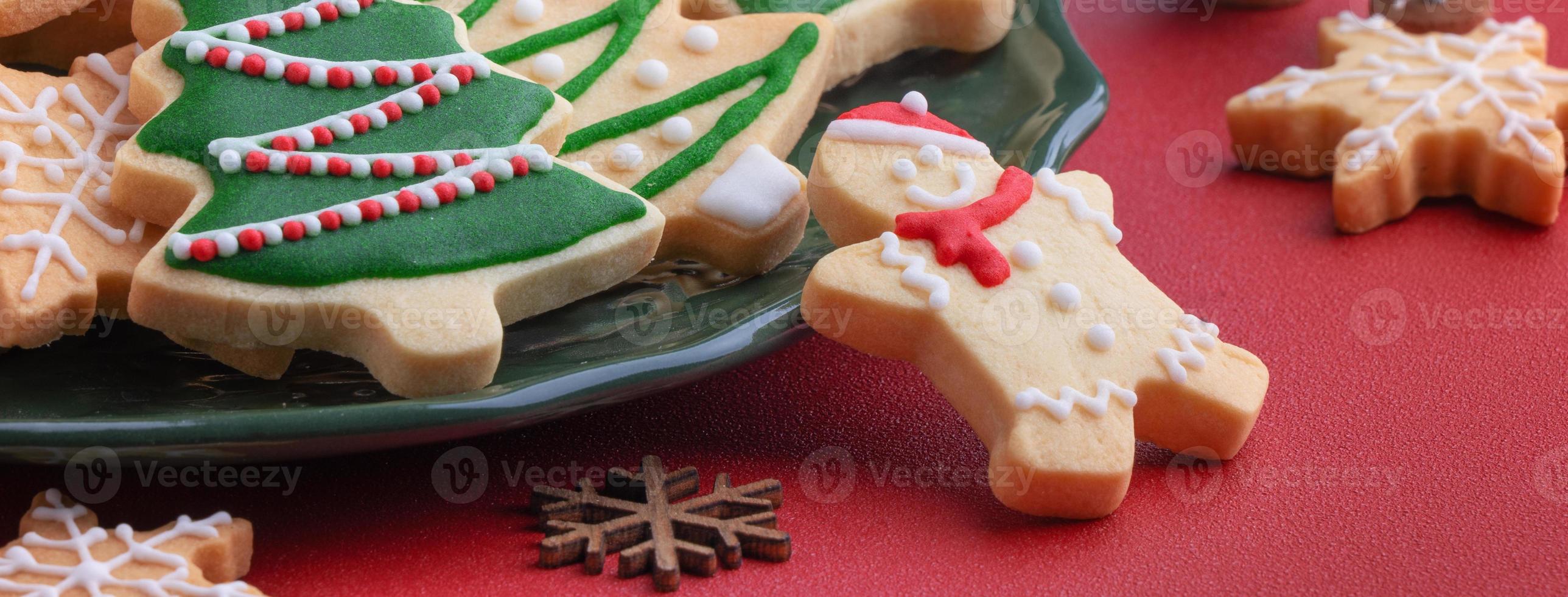 Close up of Christmas sugar cooikes in a plate on red table background. photo