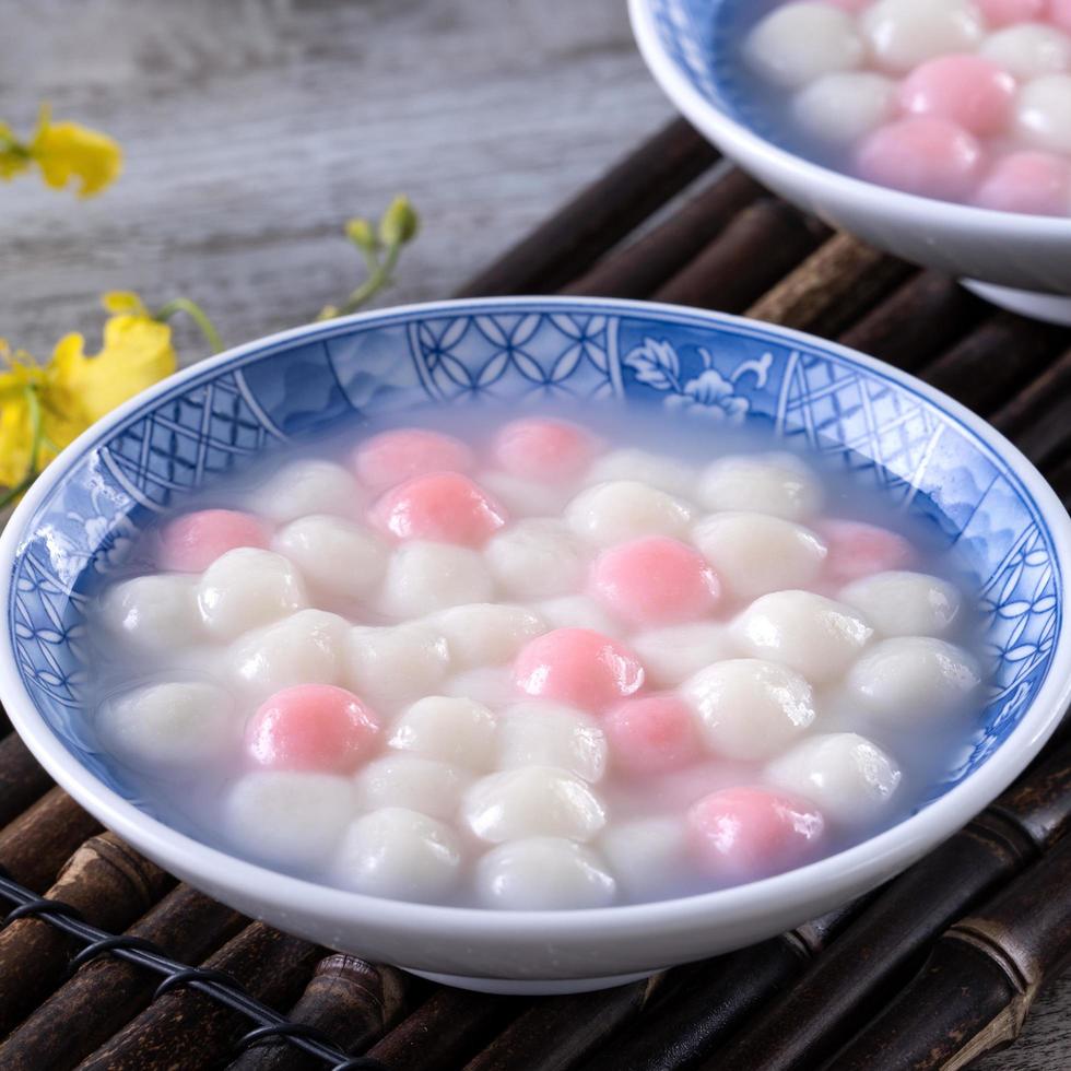 Close up of red and white tangyuan in blue bowl on wooden background for Winter solstice. photo