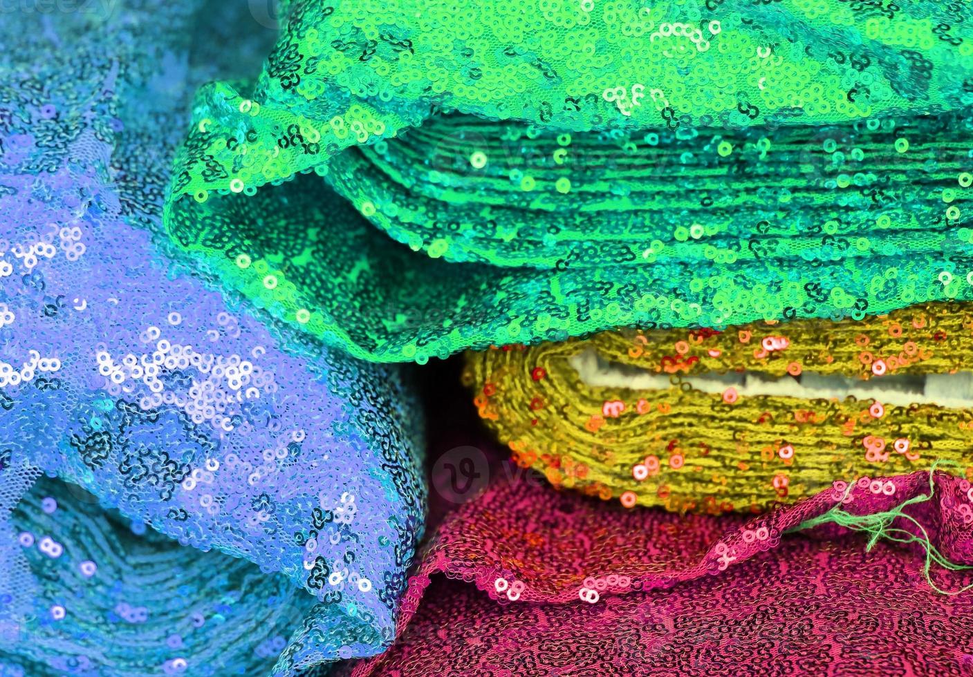 Detailed close up view on samples of cloth and fabrics in different colors found at a fabrics market photo