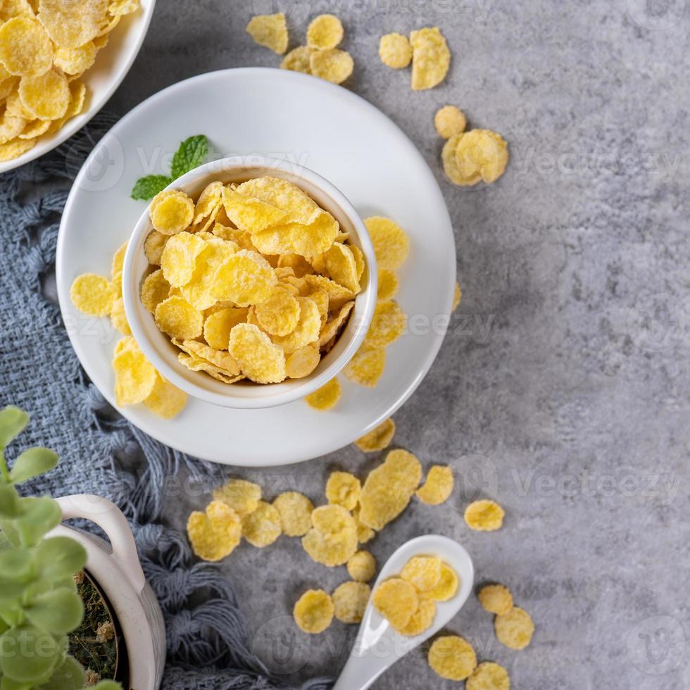 Corn flakes bowl sweets on gray cement background, top view flat lay layout design, fresh and healthy breakbast concept. photo