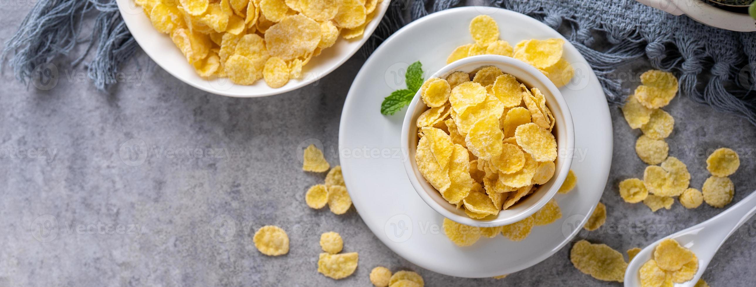 Corn flakes bowl sweets on gray cement background, top view flat lay layout design, fresh and healthy breakbast concept. photo