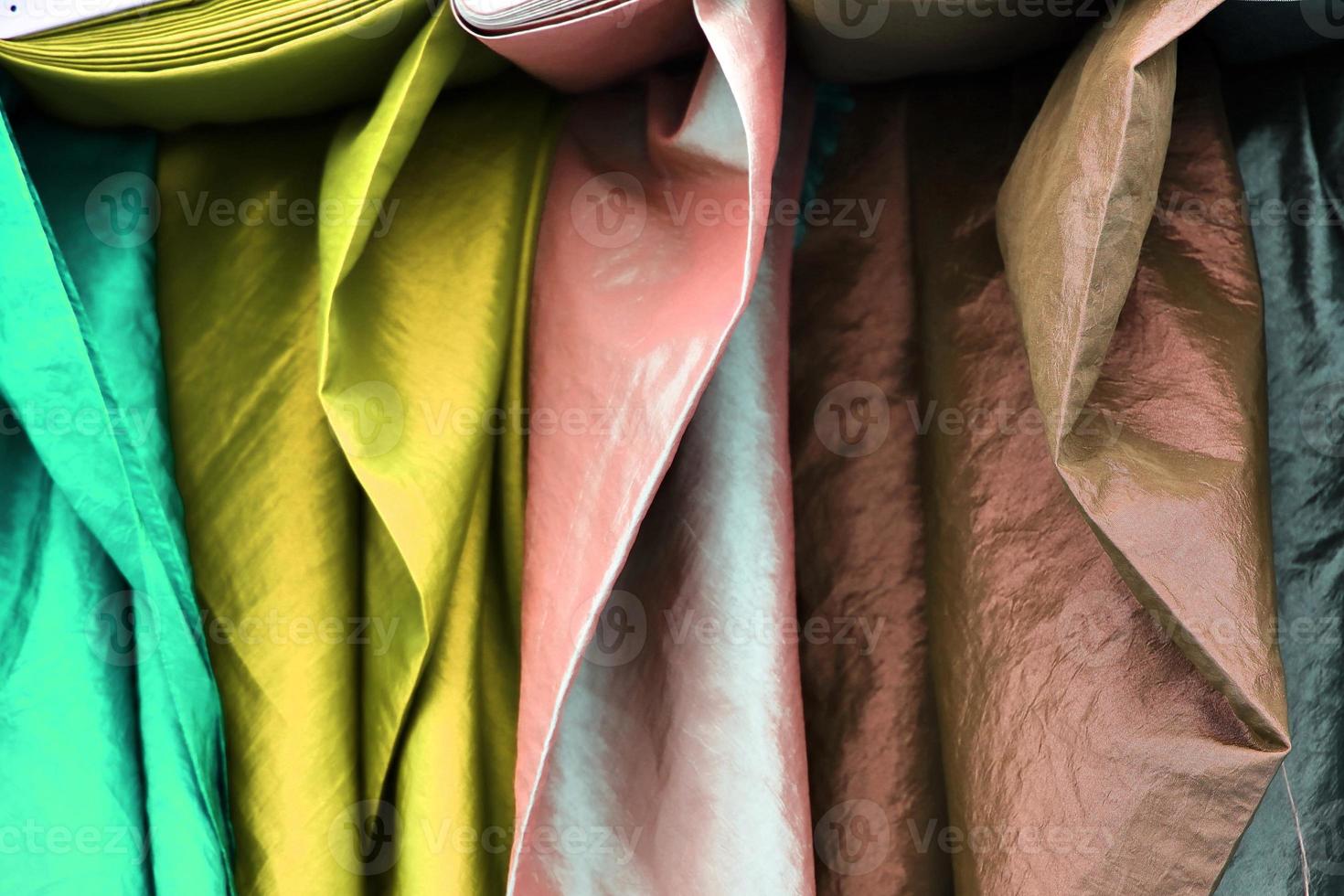 Detailed close up view on samples of cloth and fabrics in different colors found at a fabrics market photo