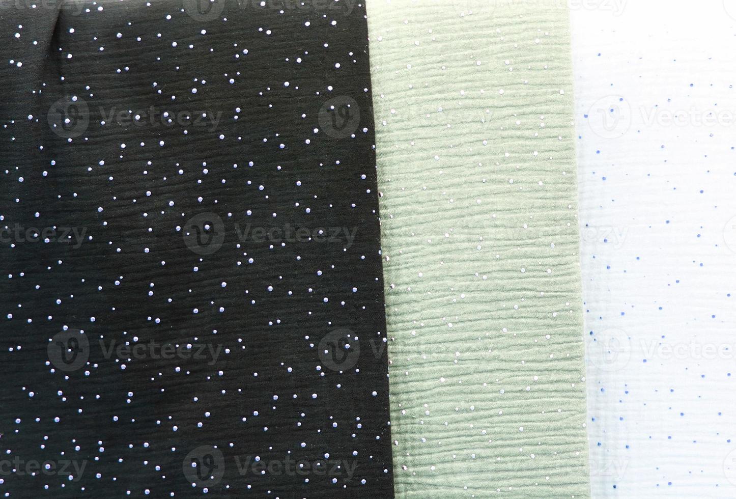 Detailed close up view on samples of cloth and fabrics in different colors found at a fabrics market photo