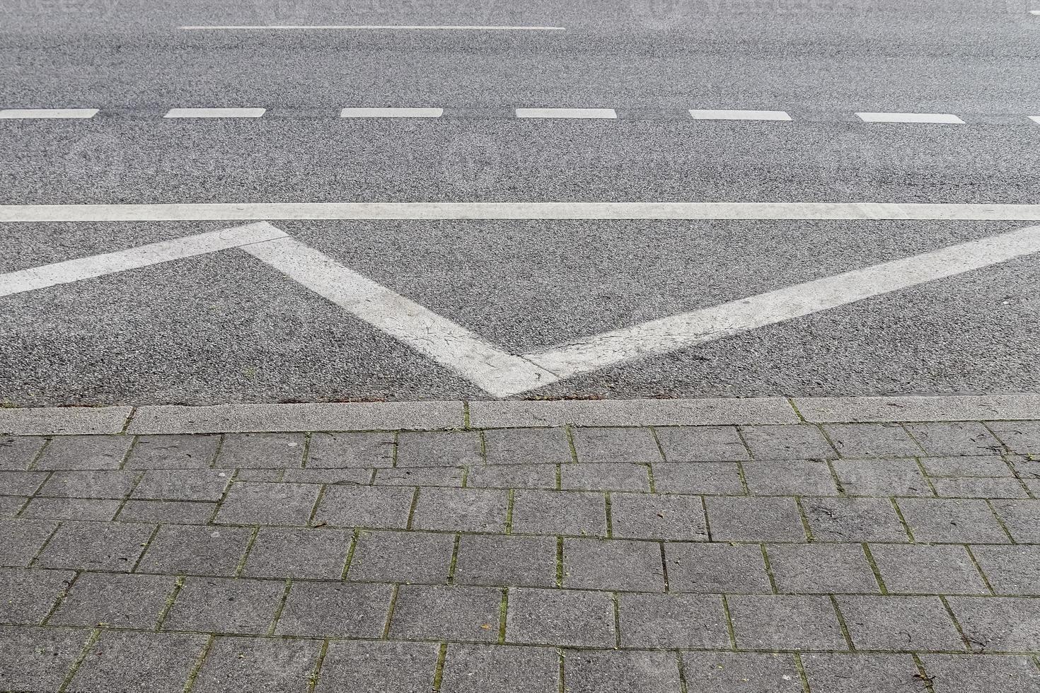 Different signs and marking painted on the ashpalt of streets and roads. photo