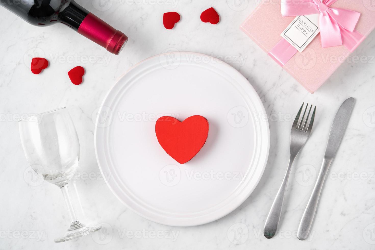 Plate with tableware, ribbon, gift and roses for Valentine's Day special meal concept. photo