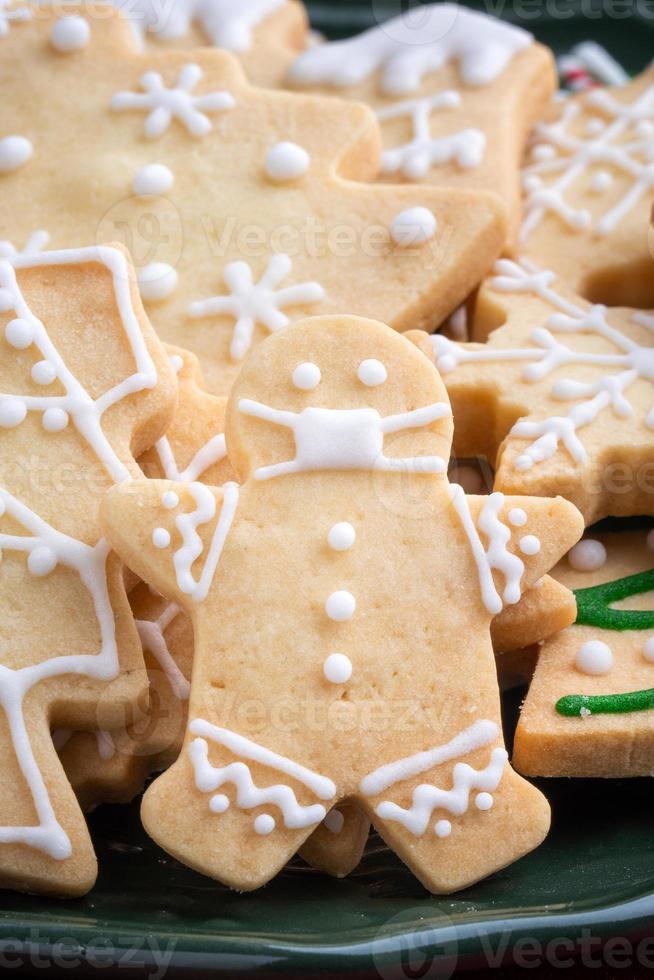 Close up of Christmas sugar cookies in a plate on red table background. photo