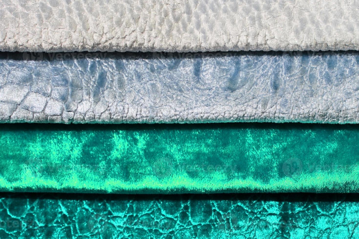 Detailed close up view on samples of cloth and fabrics in different colors found at a fabrics market photo