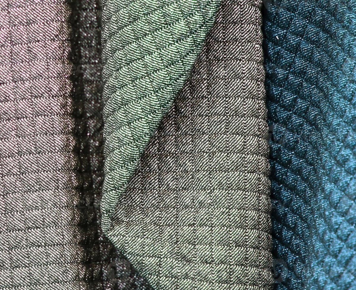Detailed close up view on samples of cloth and fabrics in different colors found at a fabrics market photo