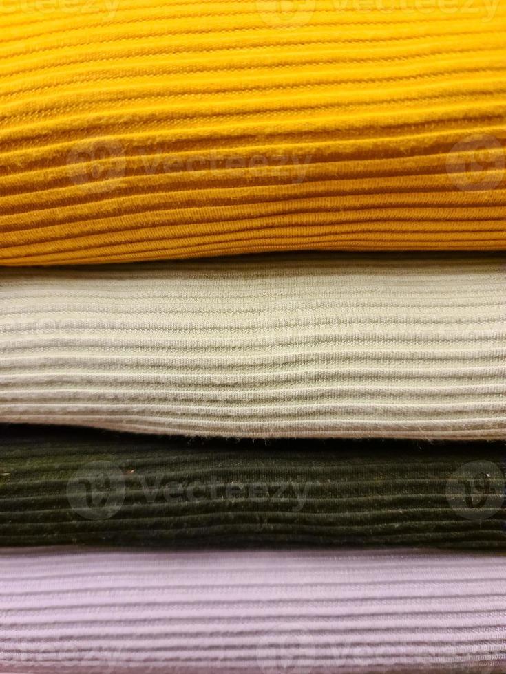 Detailed close up view on samples of cloth and fabrics in different colors found at a fabrics market photo