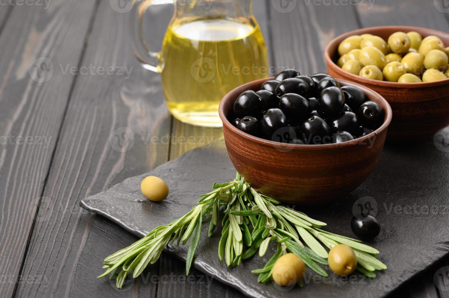 aceitunas negras y verdes sobre un fondo rústico de madera oscura. foto