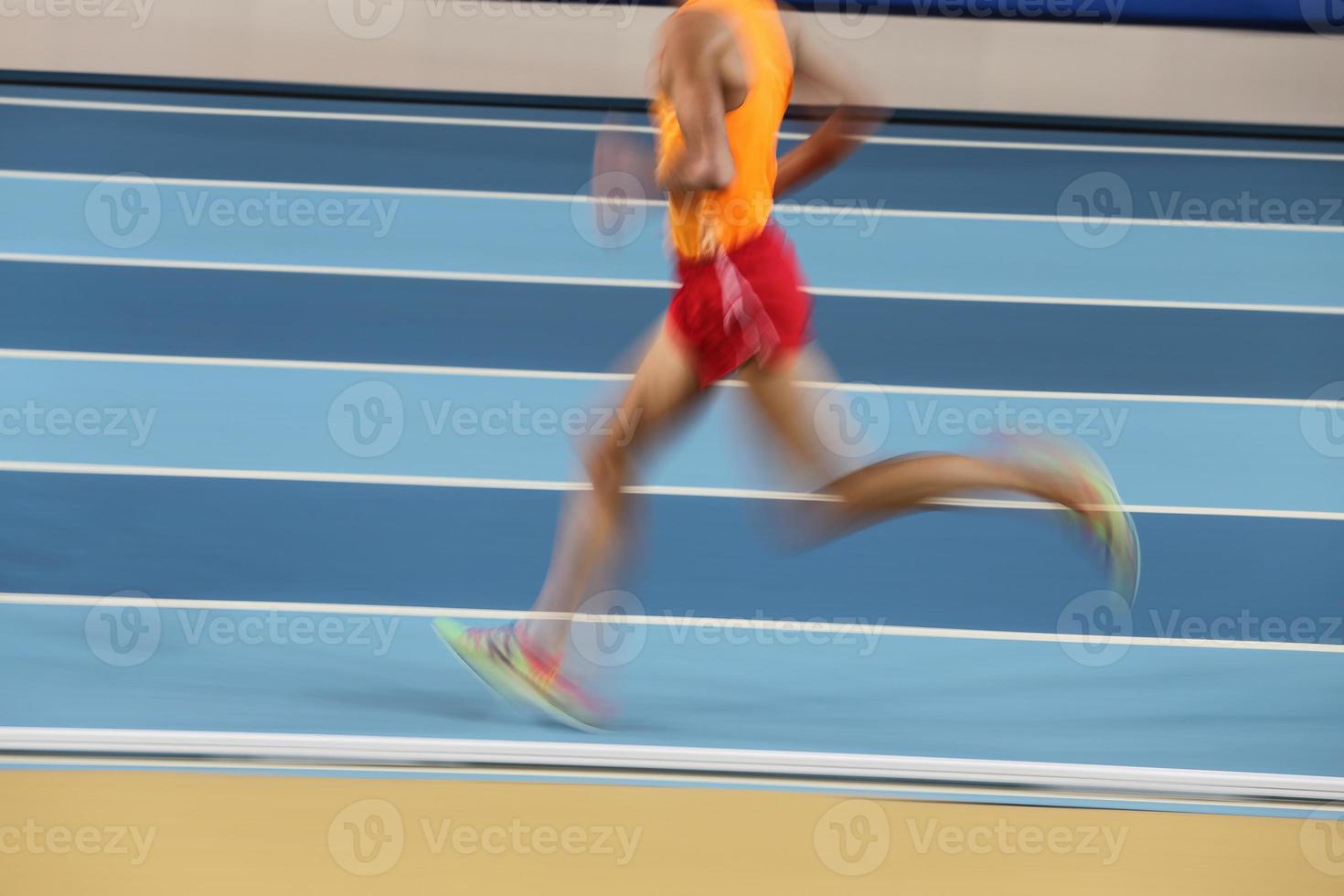 Blured athletes run in track and field photo