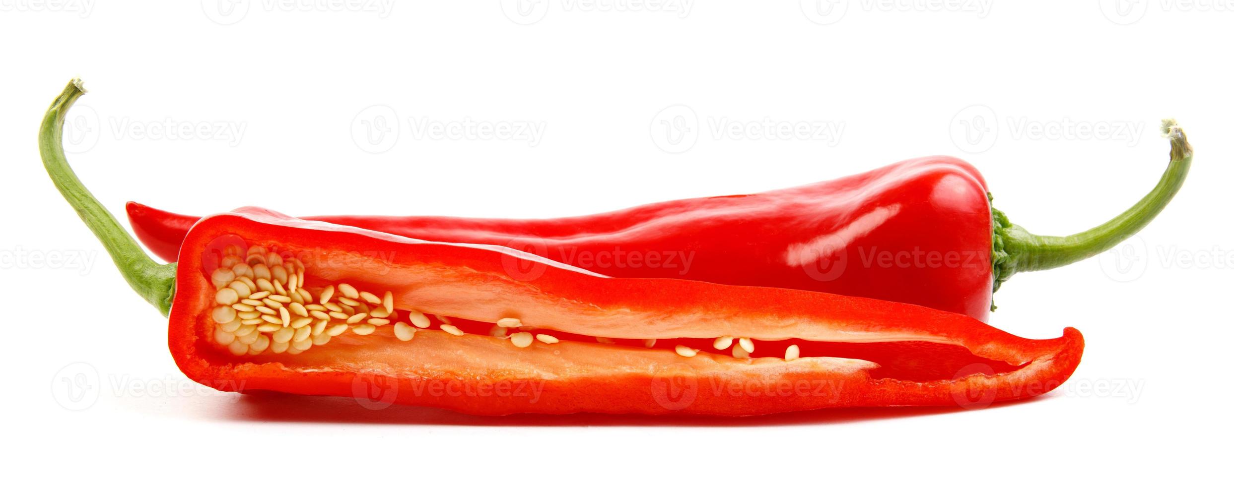 Two pods of red pepper, a whole and half are isolated on a white background. photo