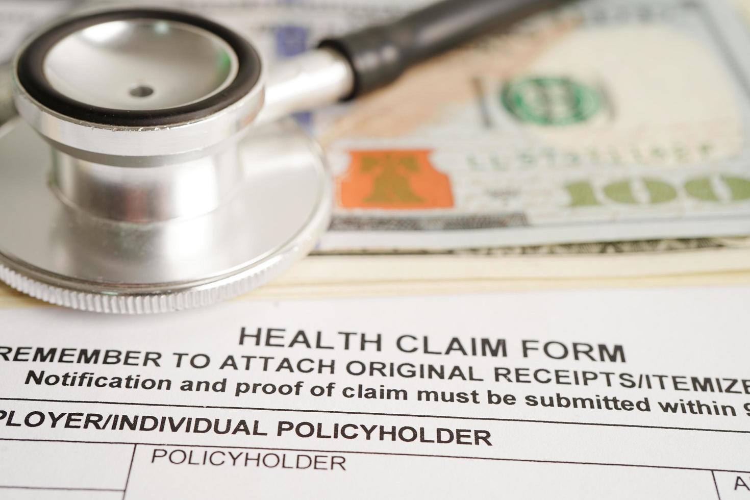 Health claim form with stethoscope and US dollar banknotes, insurance accident medical concept. photo