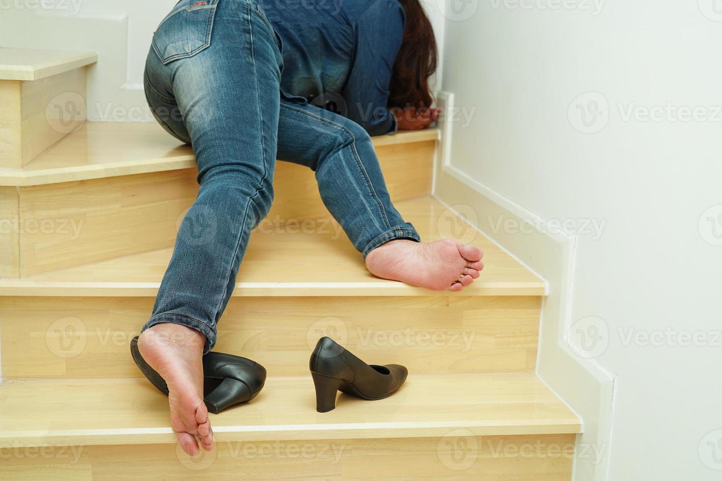 Asian business woman pain ankle, foot with leg cramp and fall down the stairs because slippery surfaces in office. photo