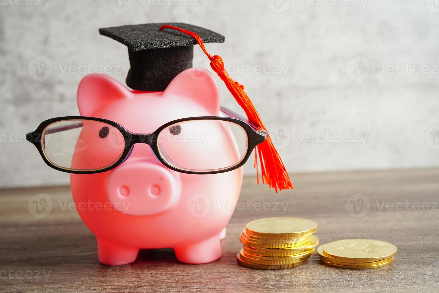 Pigging bank wearing eyeglass with coins and calculator saving bank education concept. photo