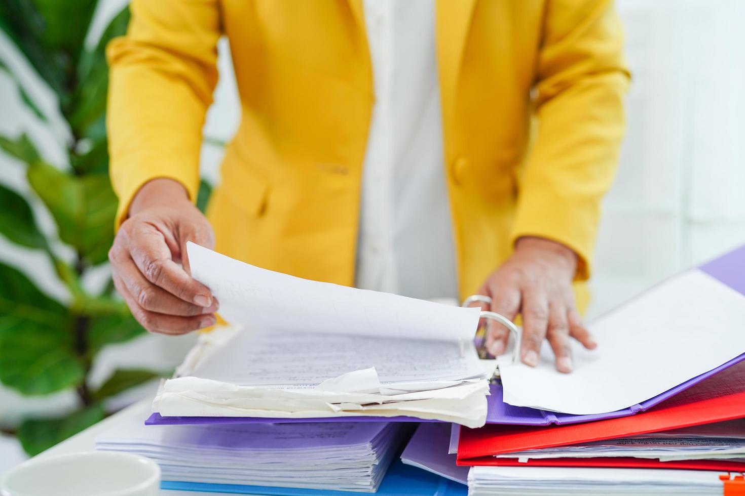 el empresario trabaja y prepara los datos del informe de papeleo para analizar la información en la carpeta de archivos en la oficina. foto