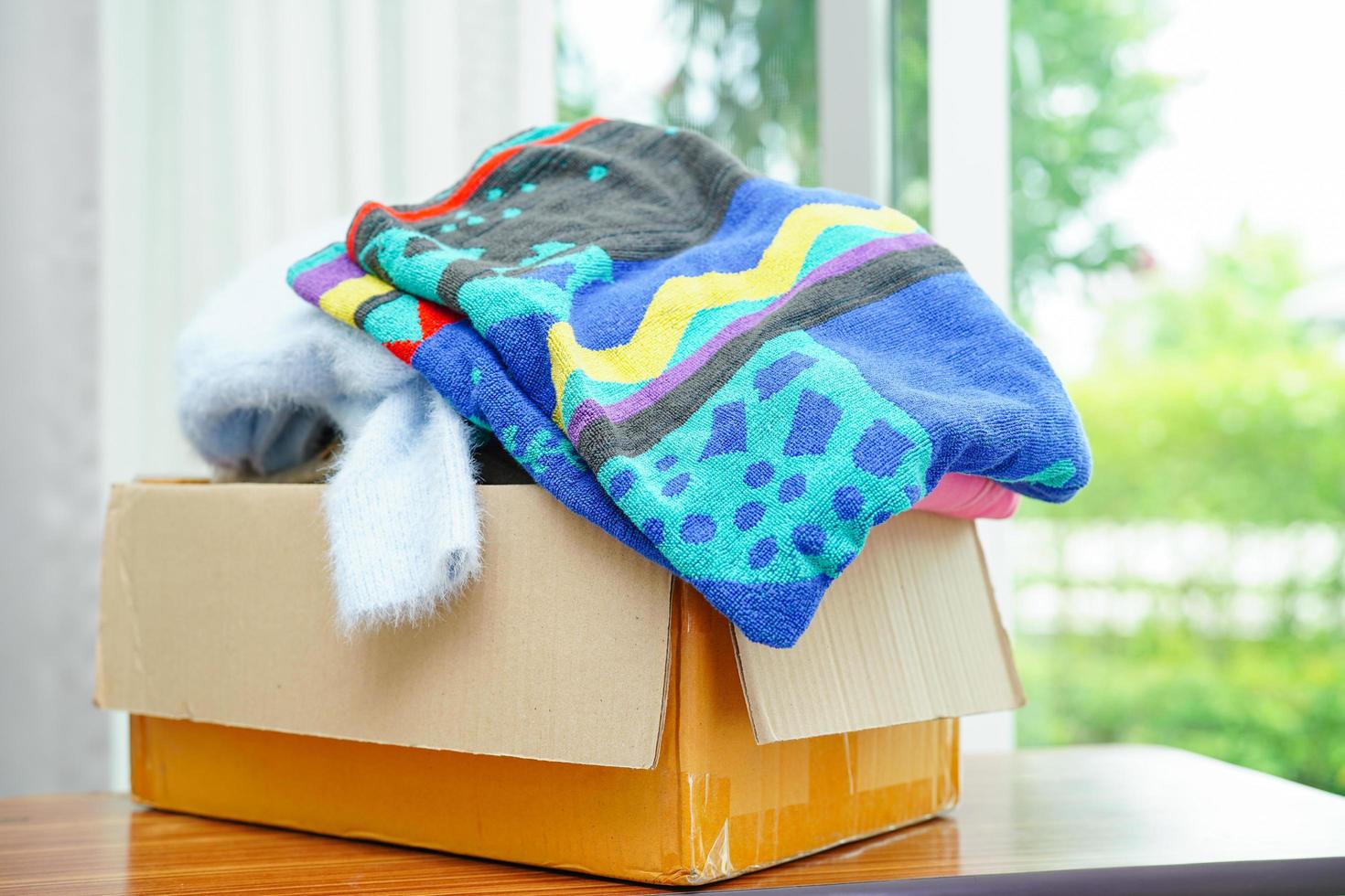 Clothes donations in cardboard box for volunteer. photo