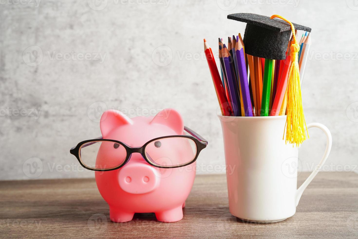 Pigging bank wearing eyeglass with coins and calculator saving bank education concept. photo