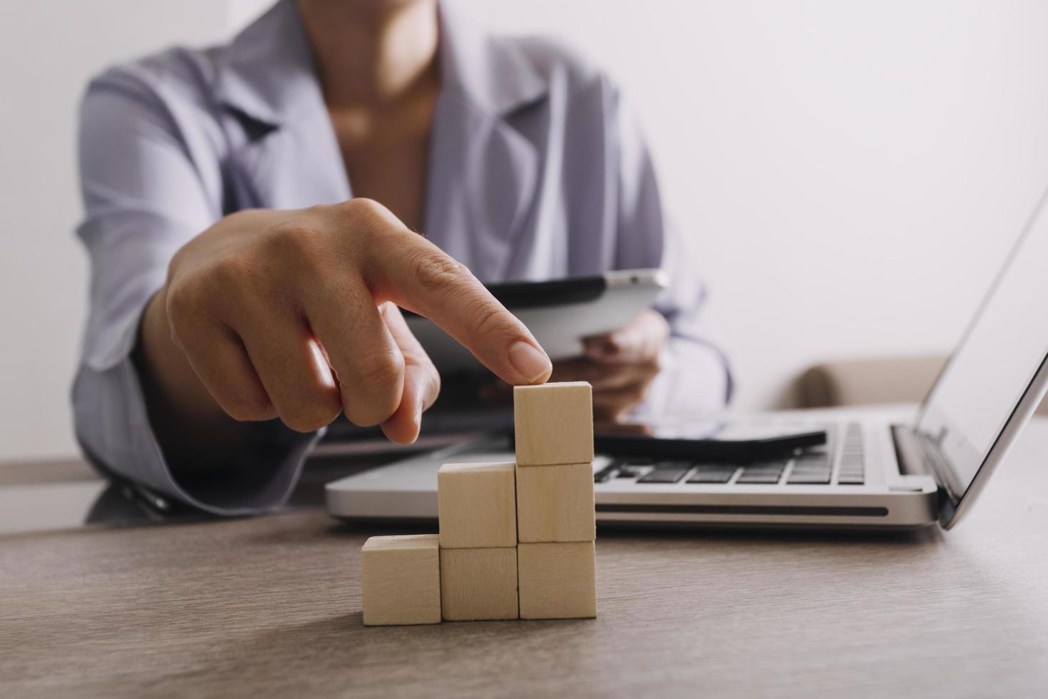 businessman hand stack woods block step on table. business development concept.arranging wood block with icon business strategy and Action plan. photo