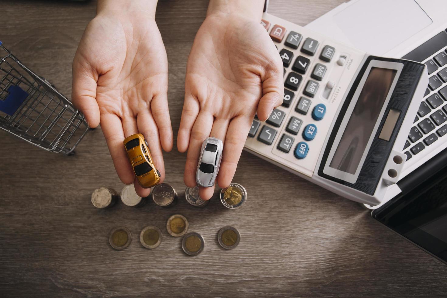 Close up of hand putting coin on pile coins for saving money. Collect money to buy a new car, saving and car loan concept. Flat lay photo