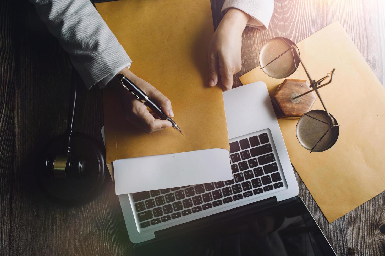 Business and lawyers discussing contract papers with brass scale on desk in office. Law, legal services, advice, justice and law concept picture with film grain effect photo